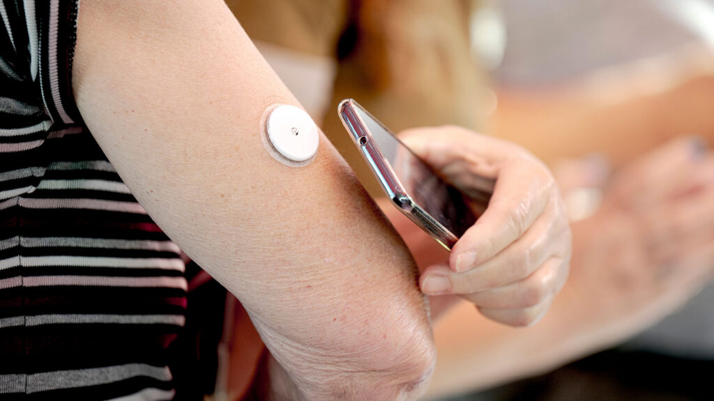 Kvinde måler blodsukker med sensor