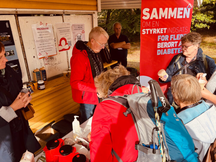 gruppe af mennesker står sammen om en frivilligstand.