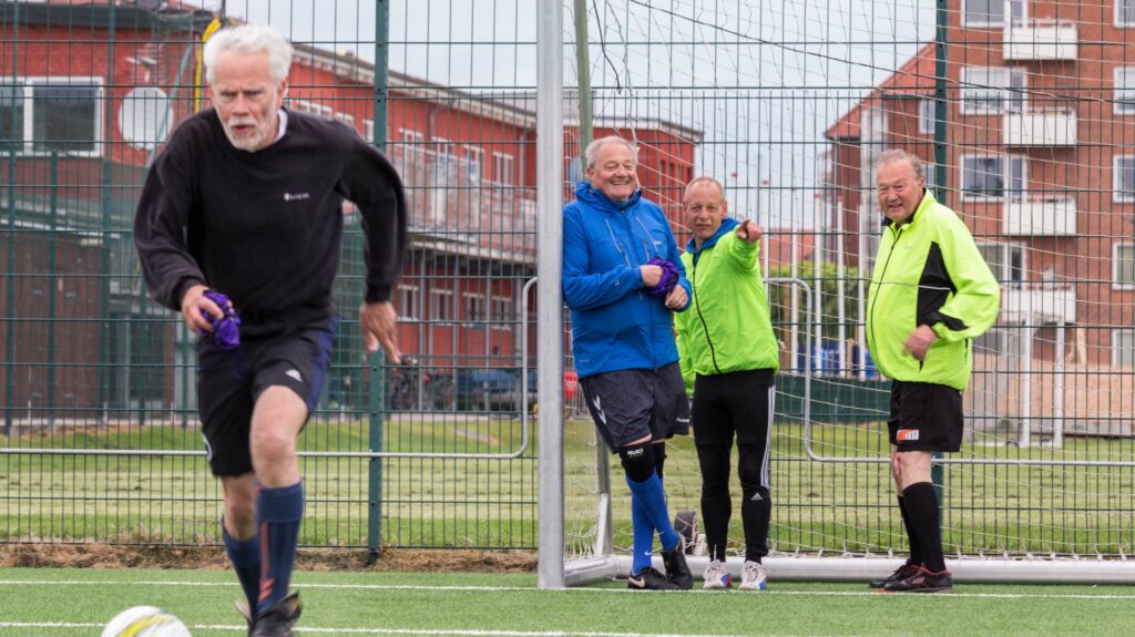 Billedet forestiller 4 mænd, der spiller fodbold